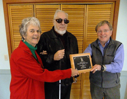 Jeanette and Bruce Travis are presented award by Ken Dane