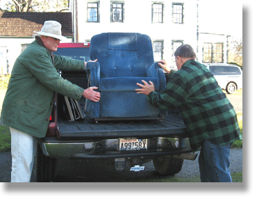 Rich and Walt load a lift chair onto a truck.